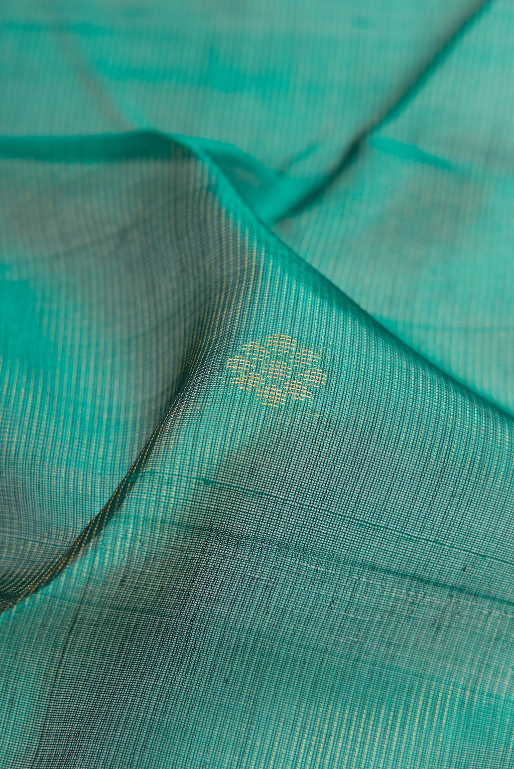 Close up of Bottle Green Silk Cotton Saree with Zari Butta on the body and Zari Border.  displaying folds
