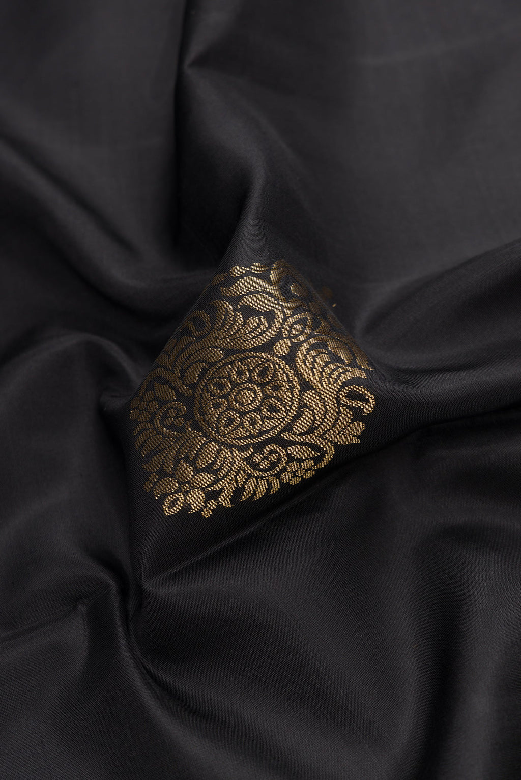 Close up of Black Dual Tone Soft Silk Saree with Zari Butta on the body and Zari Border.  displaying folds
