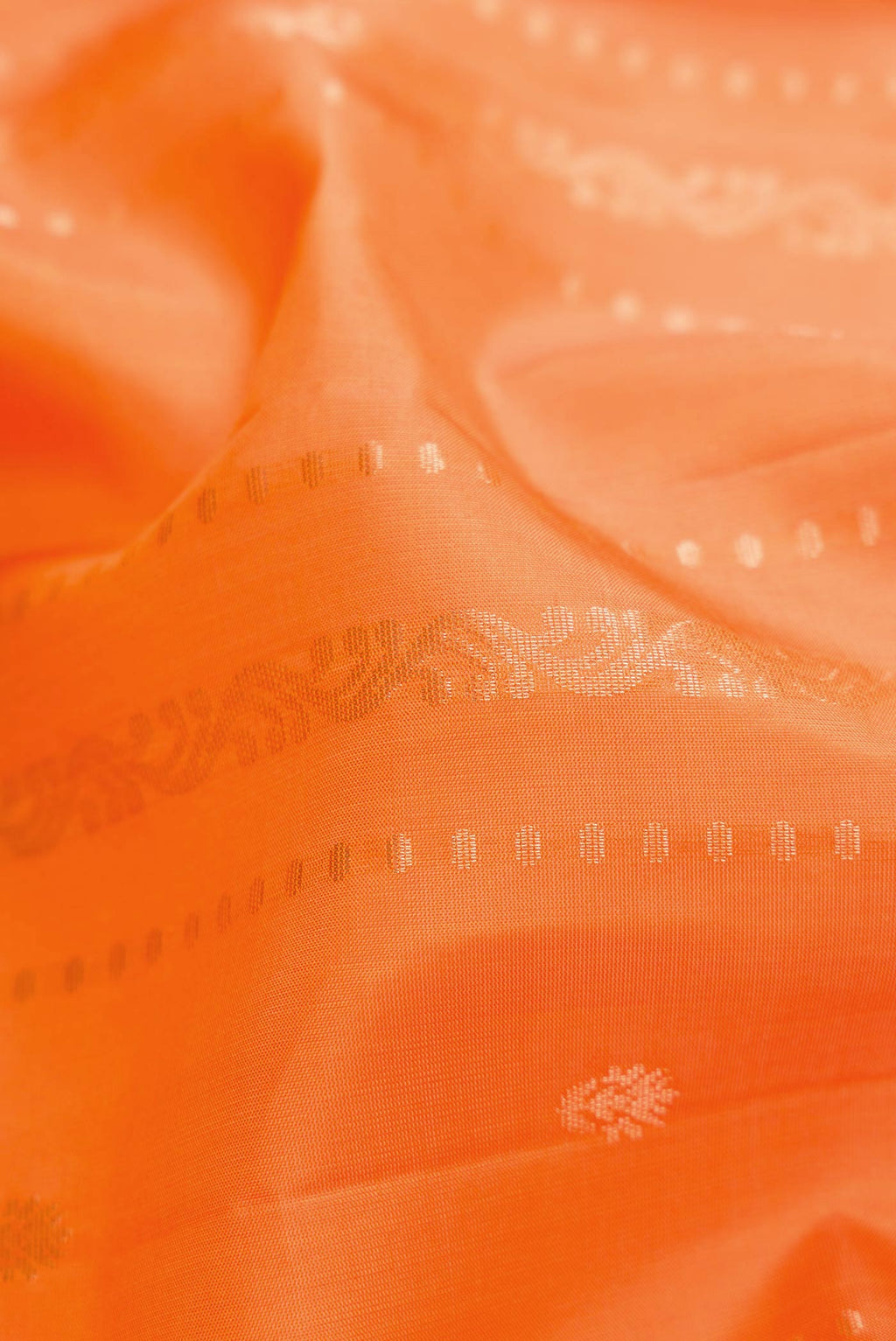 Close up of Orange Dual Tone Soft Silk Saree with Stripes on the body and Zari Border displaying folds