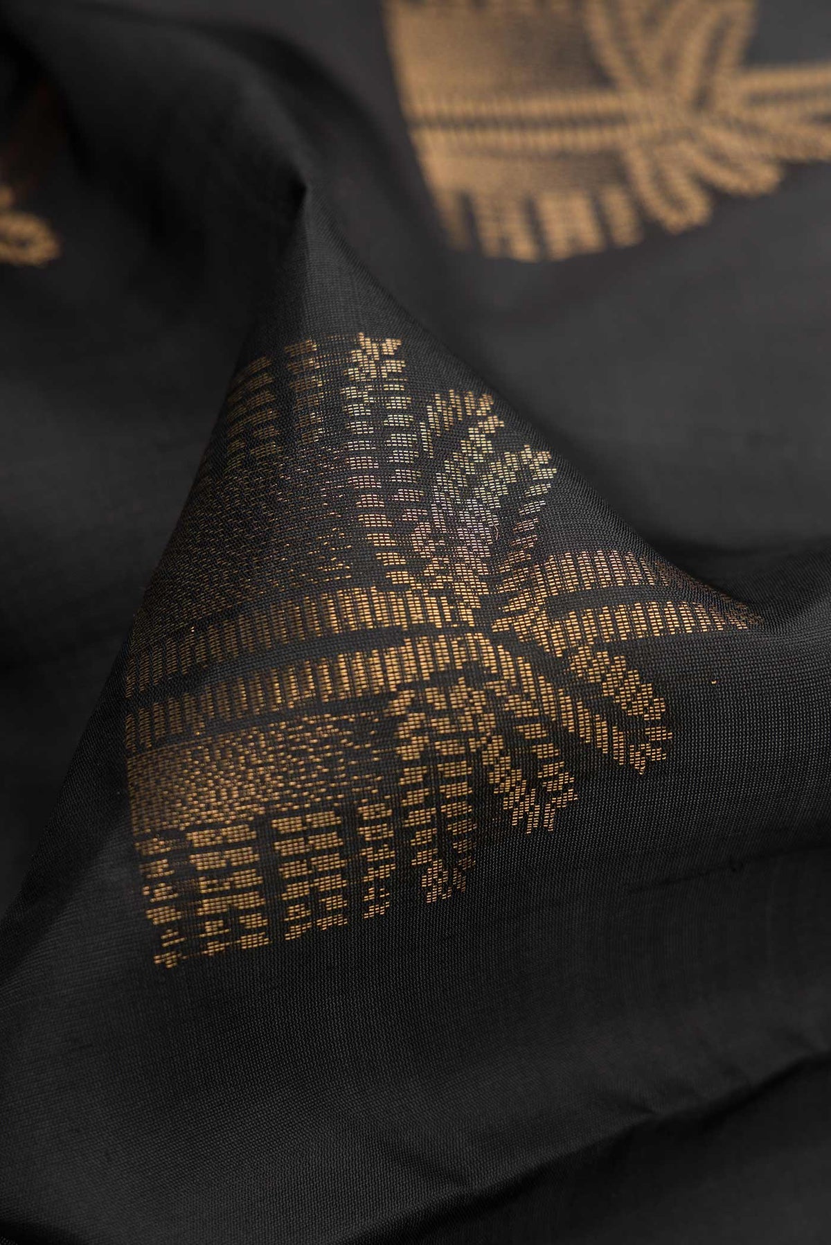Close up of Black Dual Tone Soft Silk Saree with Zari Butta on the body and Without Border.  displaying folds