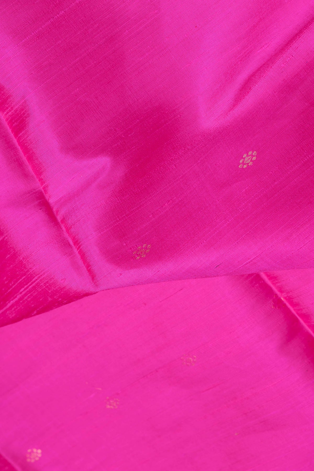 Close up of Dark Pink Dual Tone Raw Silk Saree with Zari Butta on the body and Fancy Border.  displaying folds