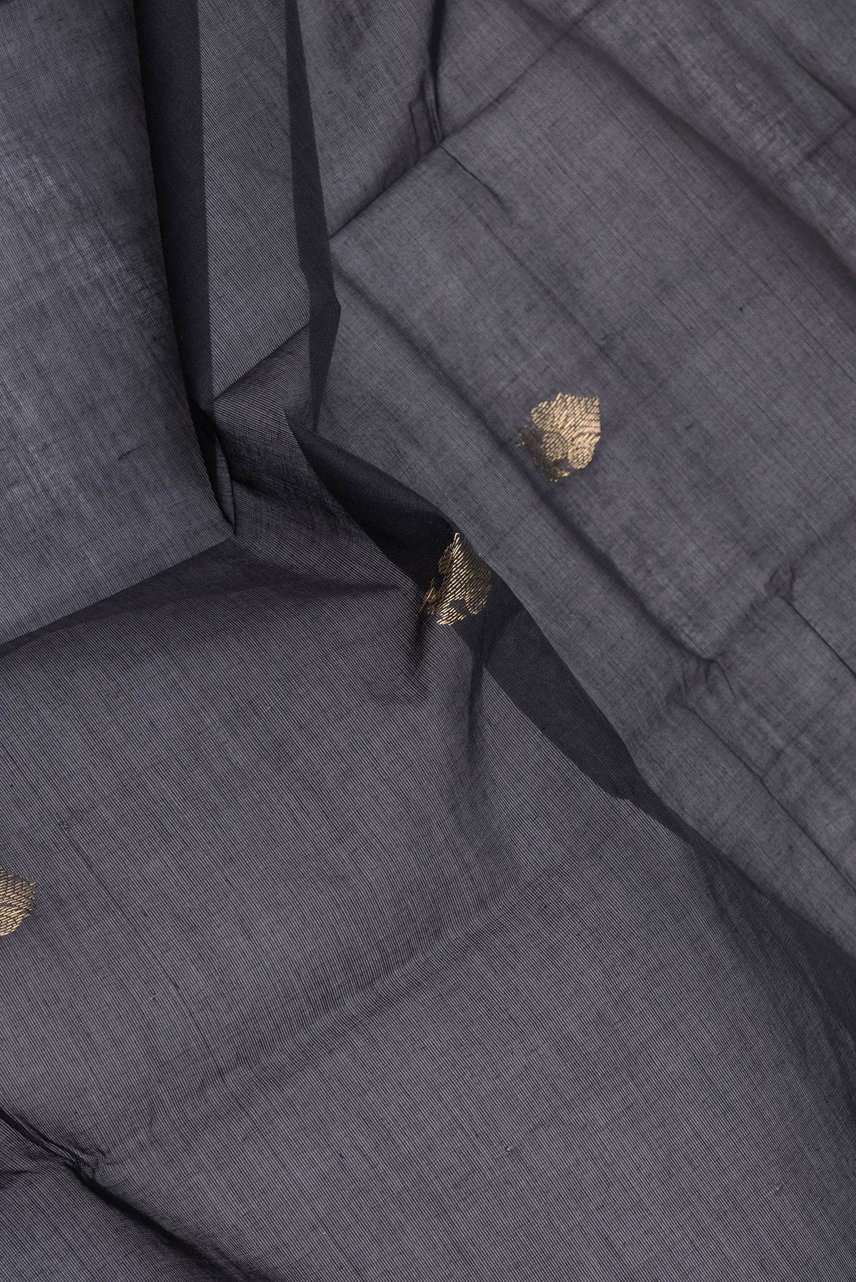 Close up of Black Kanchi Cotton Saree with Zari Butta on the body and Zari Border.  displaying folds