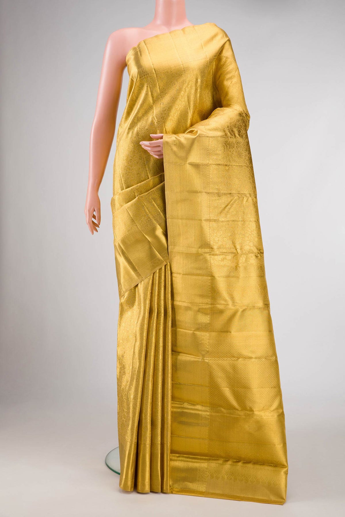 Pure Silk Pure Zari Gold Dual Tone Kanjivaram Tissue Saree with Zari Brocade on the body and Zari Border.  displayed on a mannequin