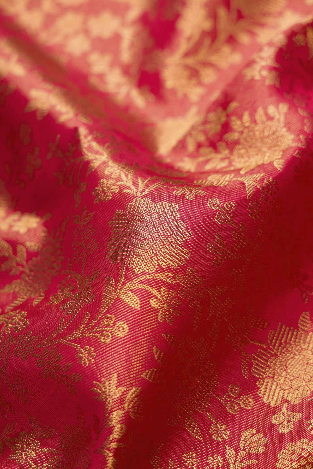 Close up of Pure Silk Pure Zari Red Dual Tone Kanjivaram Tissue Saree with Zari Brocade on the body and Zari Border.  displaying folds