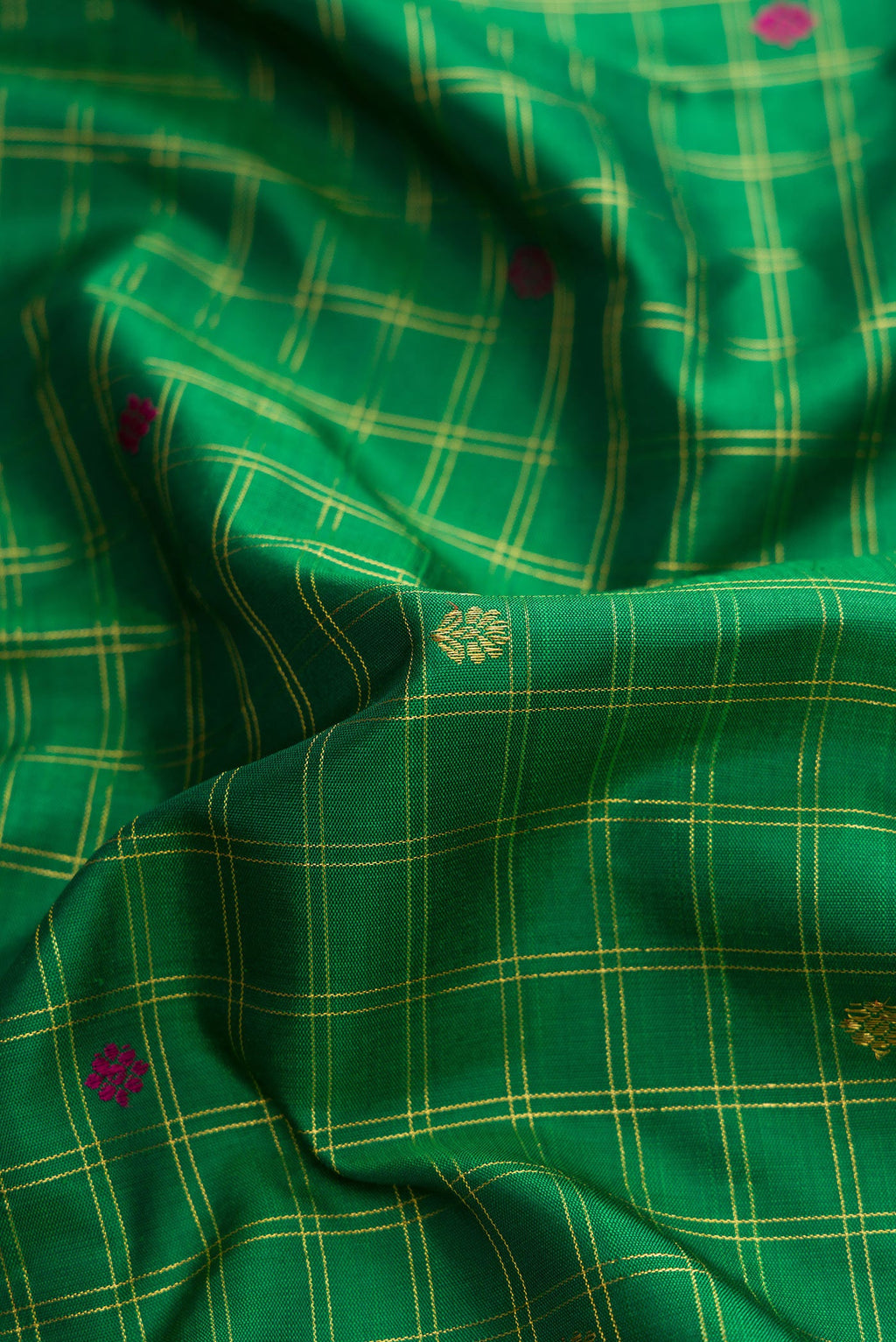 Close up of Pure Silk Pure Zari Green Dual Tone Kanjivaram Saree with Checked design on the body and Zari And Thread Border.  displaying folds