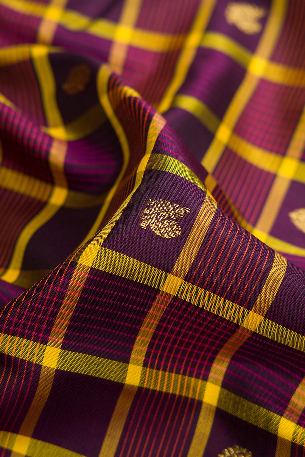 Close up of Pure Silk Pure Zari Burgundy Dual Tone Kanjivaram Saree with Checked design on the body and Zari Border.  displaying folds
