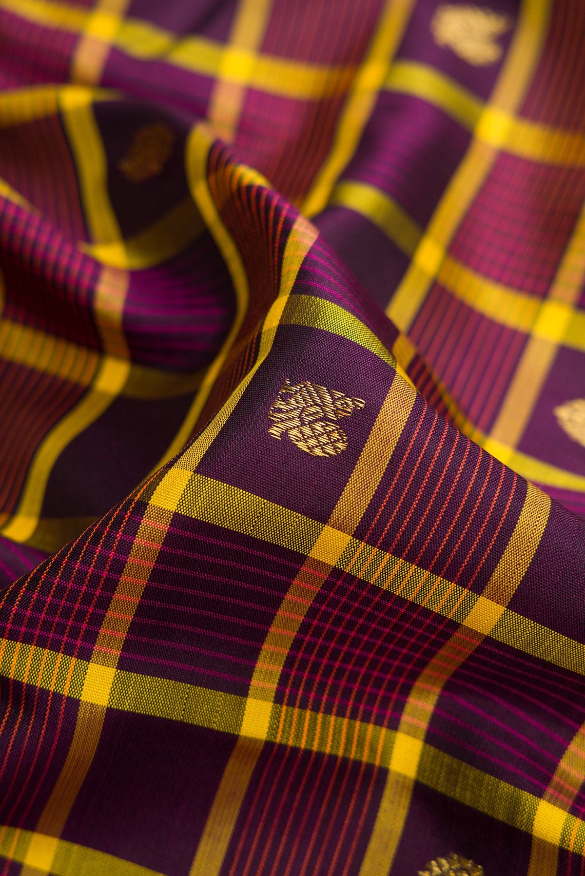 Close up of Pure Silk Pure Zari Burgundy Dual Tone Kanjivaram Saree with Checked design on the body and Zari Border.  displaying folds