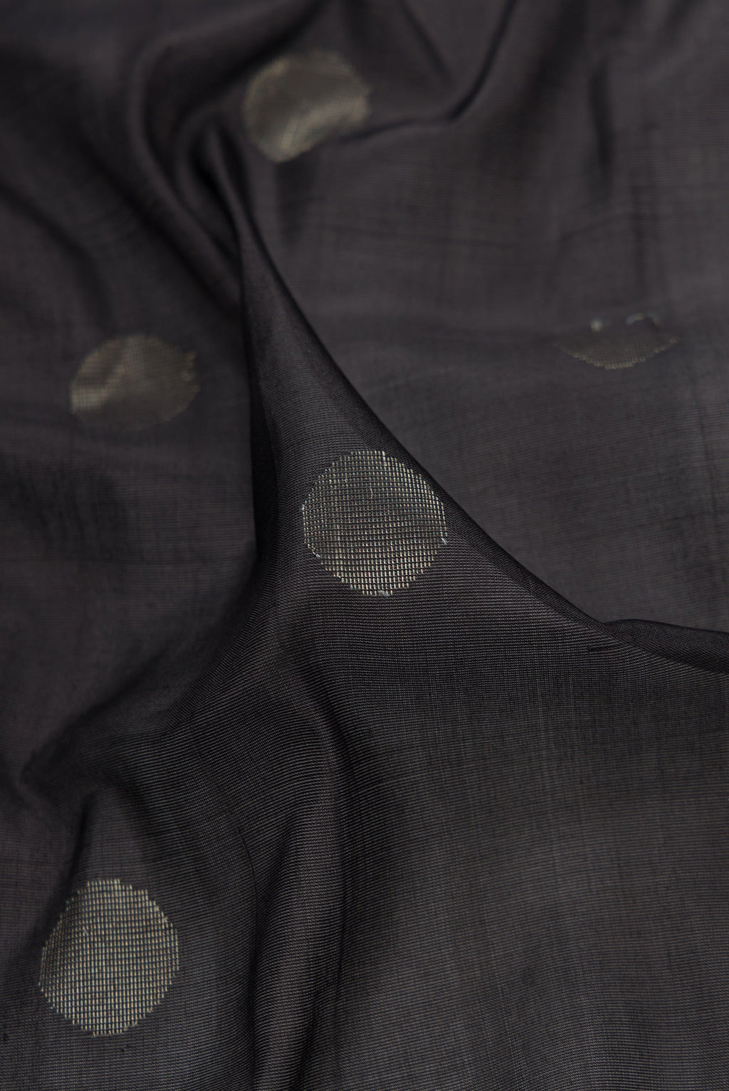Close up of Black Dual Tone Uppada Silk Saree with Zari Butta on the body and Zari Border.  displaying folds