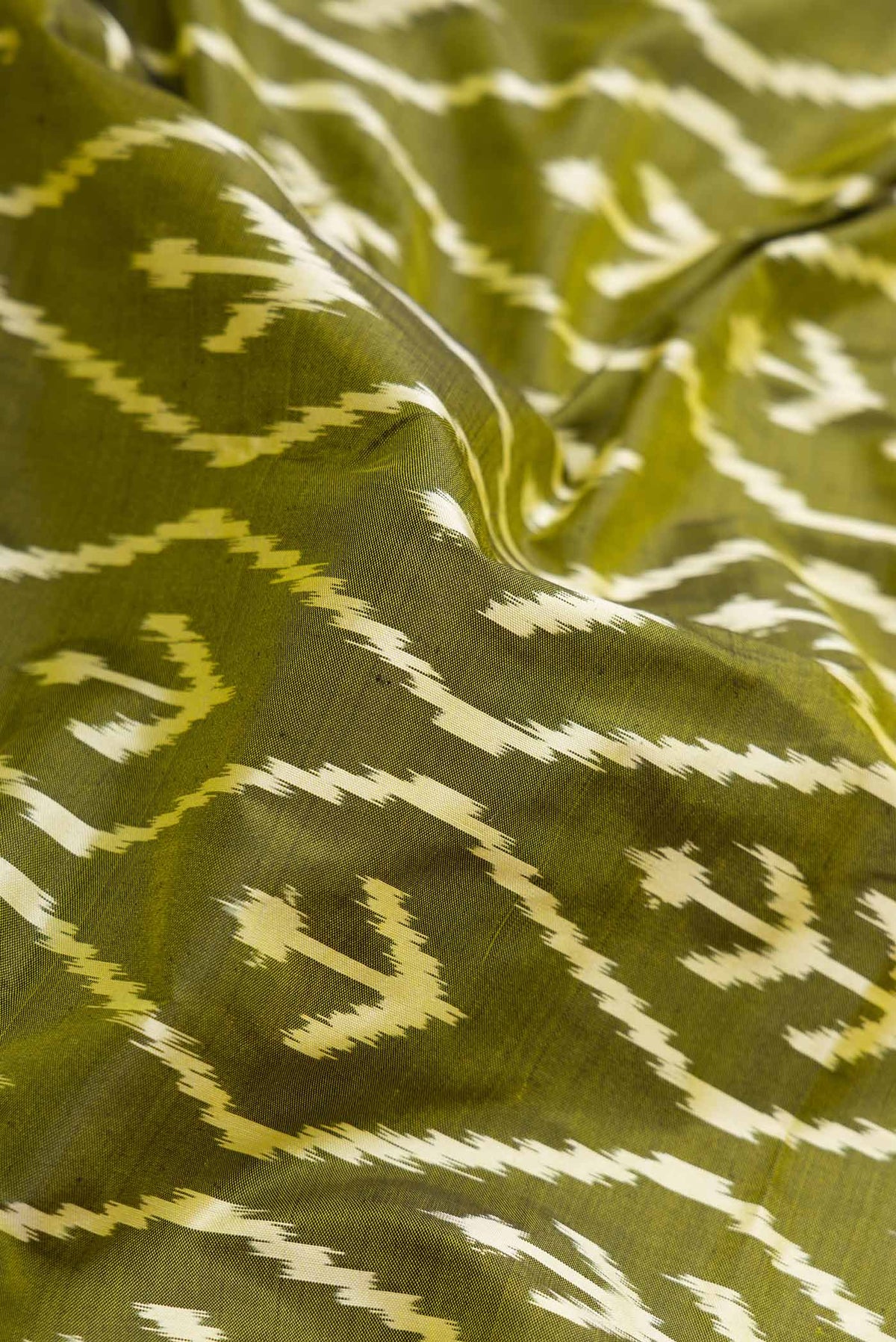 Close up of Pure Silk Pure Zari Mehandi Green Pochampally Saree with Pure Ikat on the body and Zari Border displaying folds