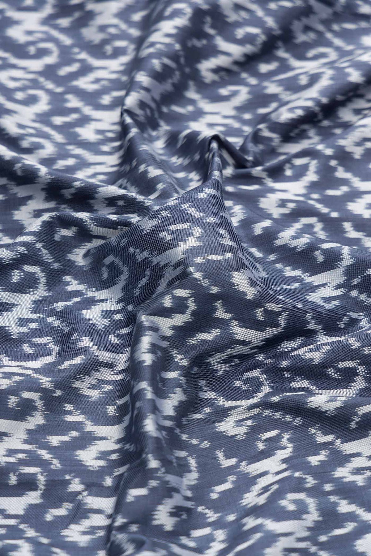 Close up of Grey Dual Tone Double Ikat Saree with Ikat Print on the body and Ikat Border displaying folds