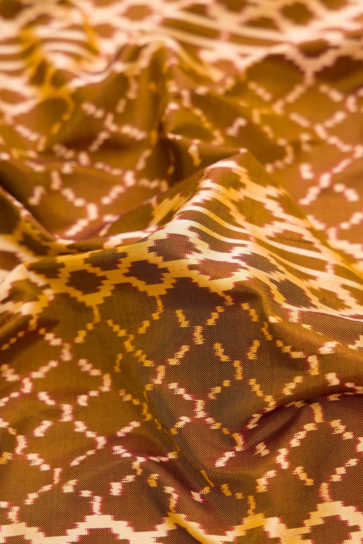 Close up of Mehandi Green Dual Tone Double Ikat Saree with Ikat Print on the body and Zari Border.  displaying folds