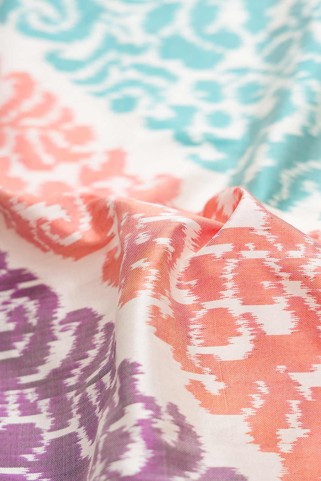 Close up of Off White Dual Tone Double Ikat Saree with Ikat Print on the body and Plain Border.  displaying folds