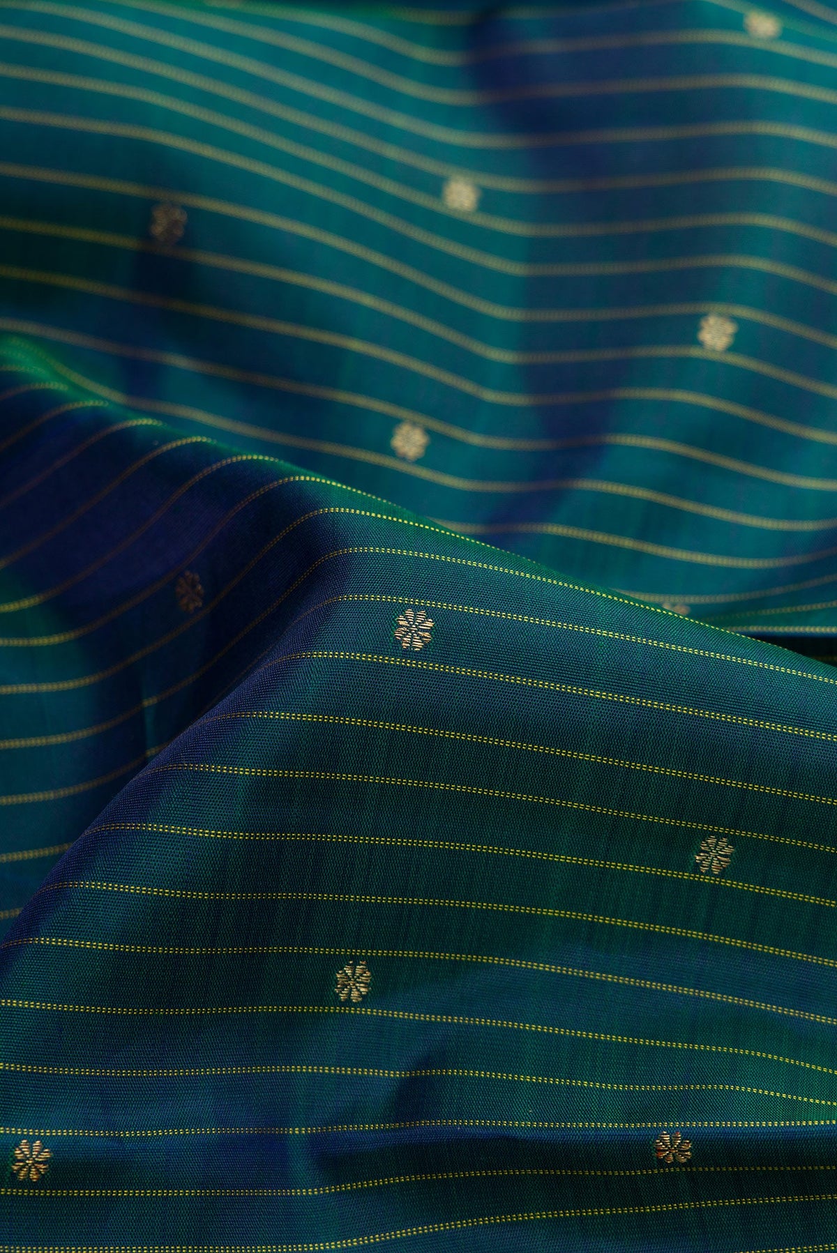 Close up of Pure Silk Pure Zari Bottle Green Dual Tone Kanchipuram Saree with Checked design on the body and Zari Border.  displaying folds