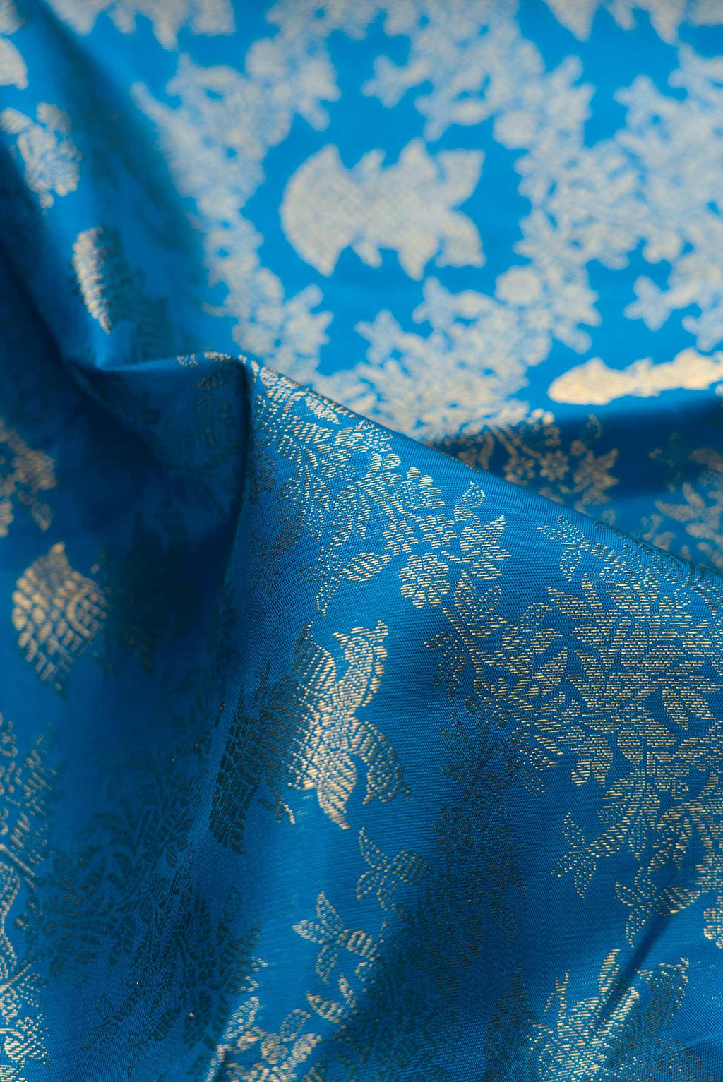 Close up of Pure Silk Pure Zari Peacock Blue Dual Tone Kanchipuram Saree with Zari Brocade on the body and Zari Border displaying folds