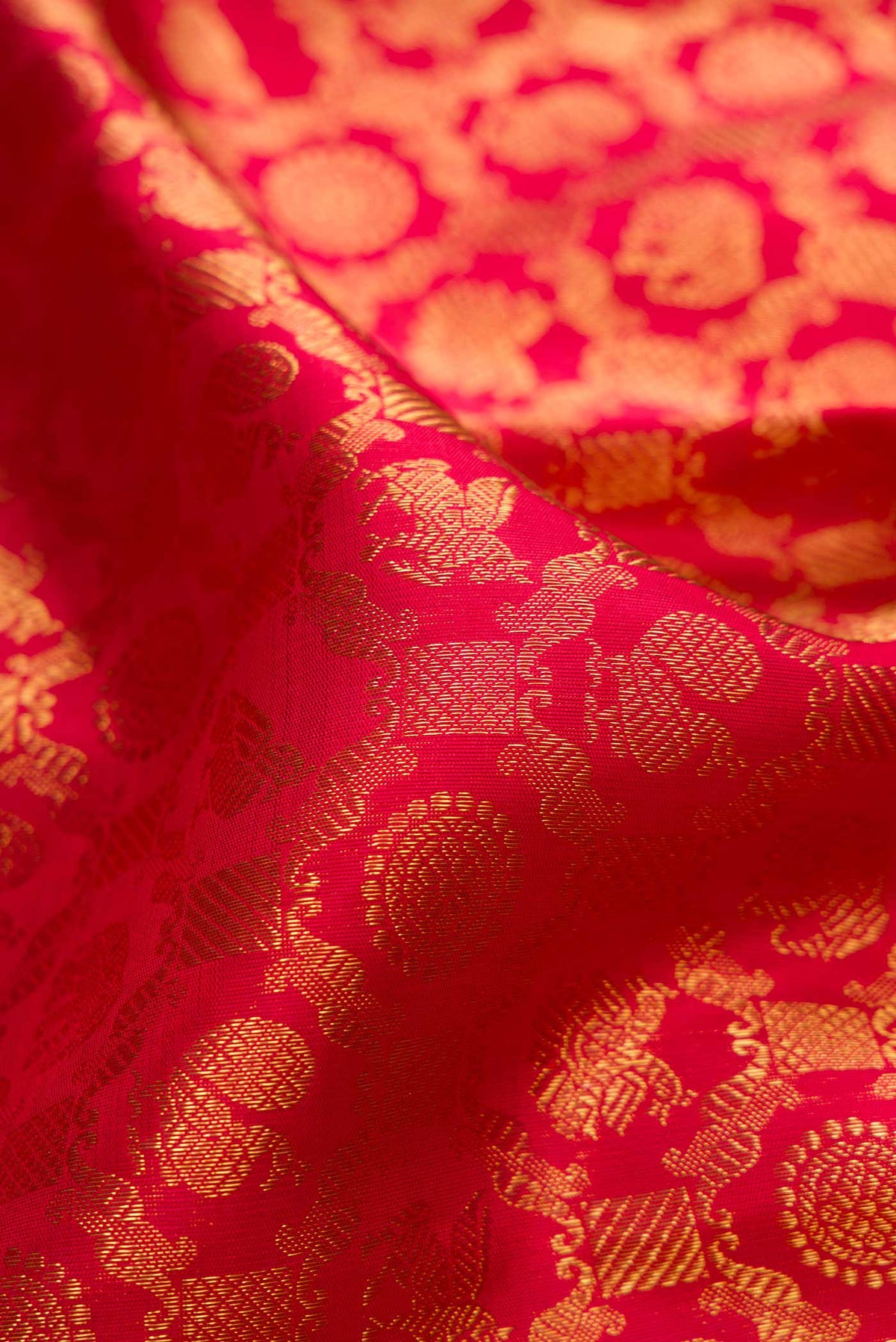 Close up of Pure Silk Pure Zari Red Dual Tone Kanchipuram Saree with Zari Brocade on the body and Zari Border displaying folds