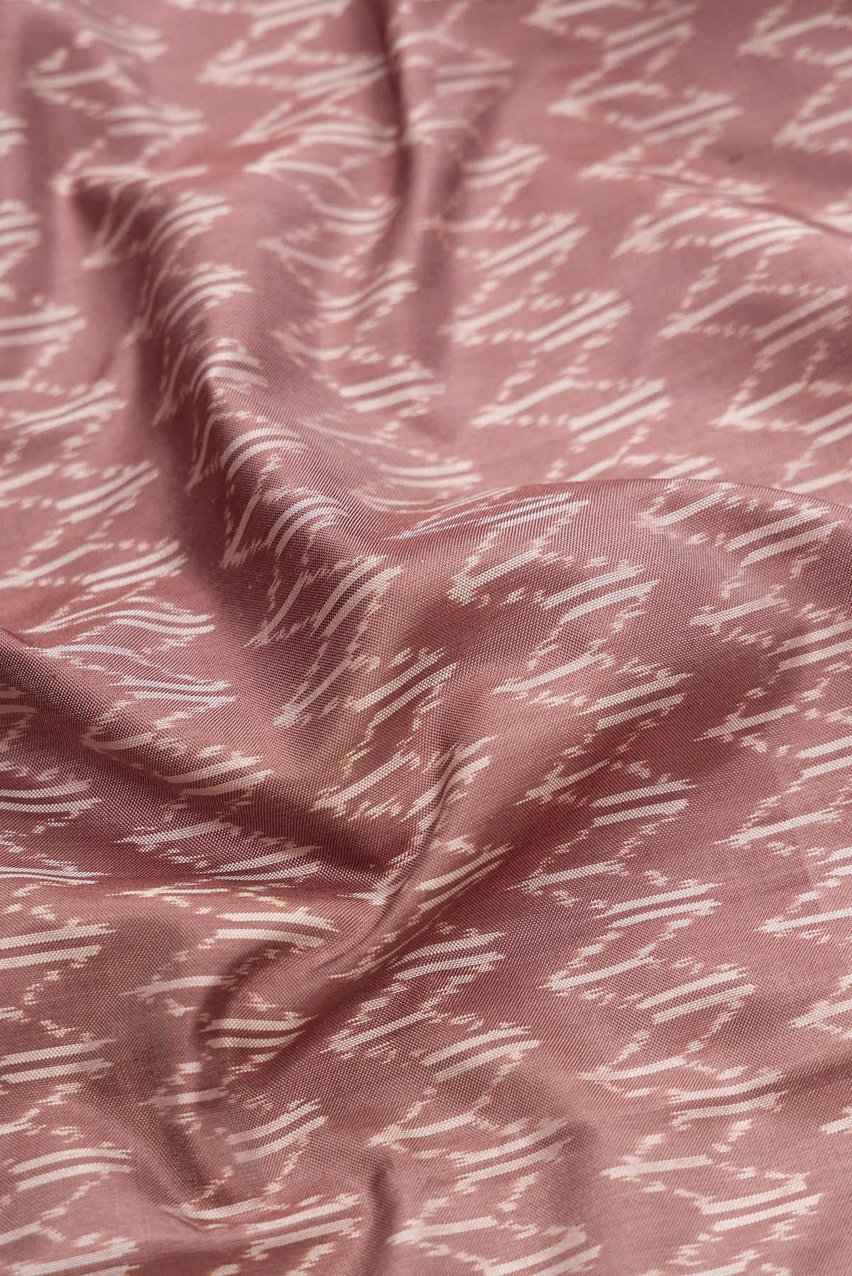 Close up of Brown Dual Tone Double Ikat Saree with Ikat Print on the body and Zari Border.  displaying folds