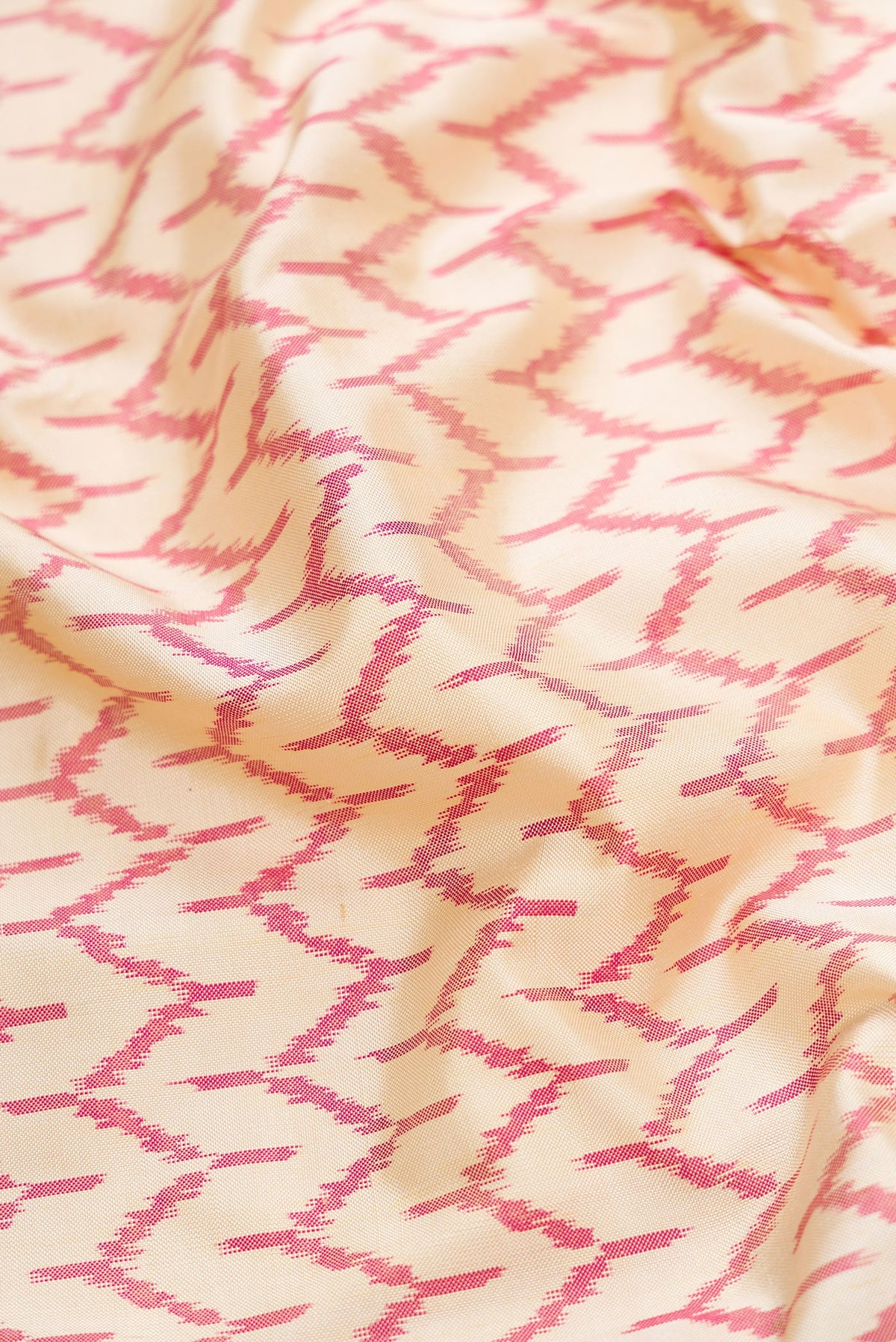 Close up of Off White Dual Tone Double Ikat Saree with Ikat Print on the body and Temple Border.  displaying folds