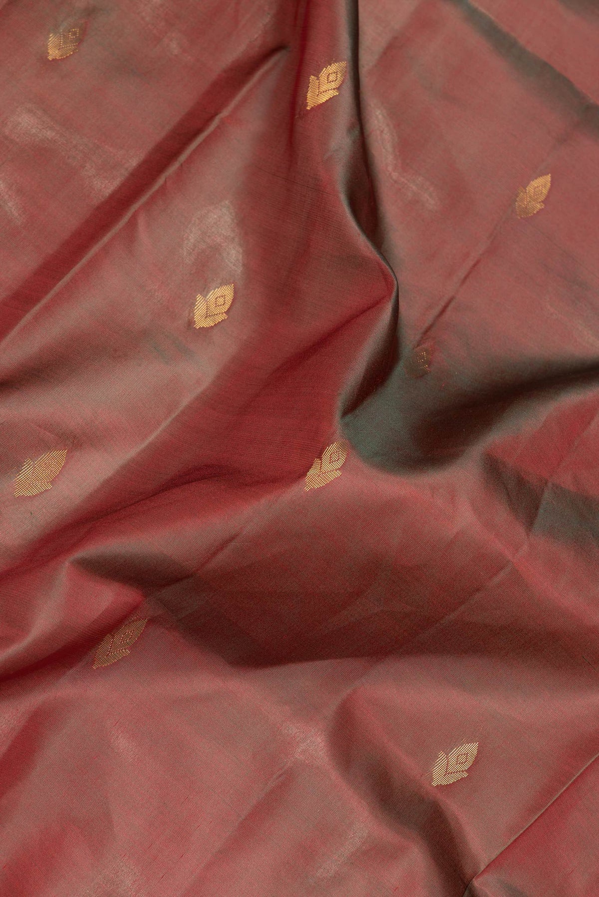 Close up of Maroon Dual Tone Soft Silk Saree with Zari Butta on the body and Fancy Border.  displaying folds