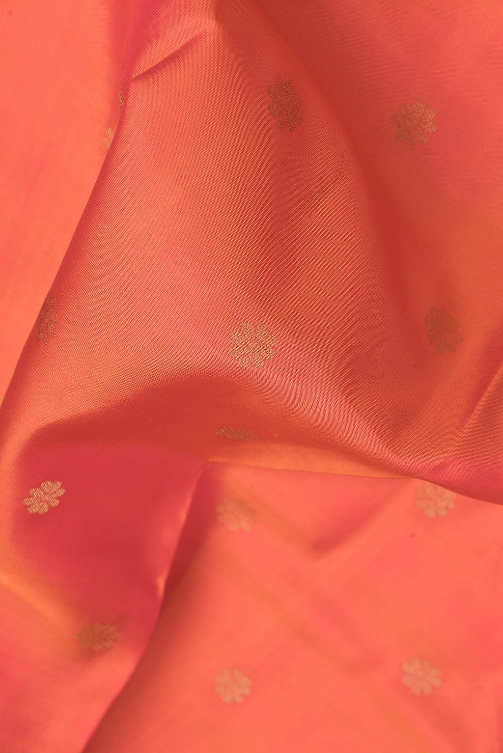 Close up of Orange Dual Tone Kanjivaram Silk Saree with Zari Butta on the body and Zari Border.  displaying folds