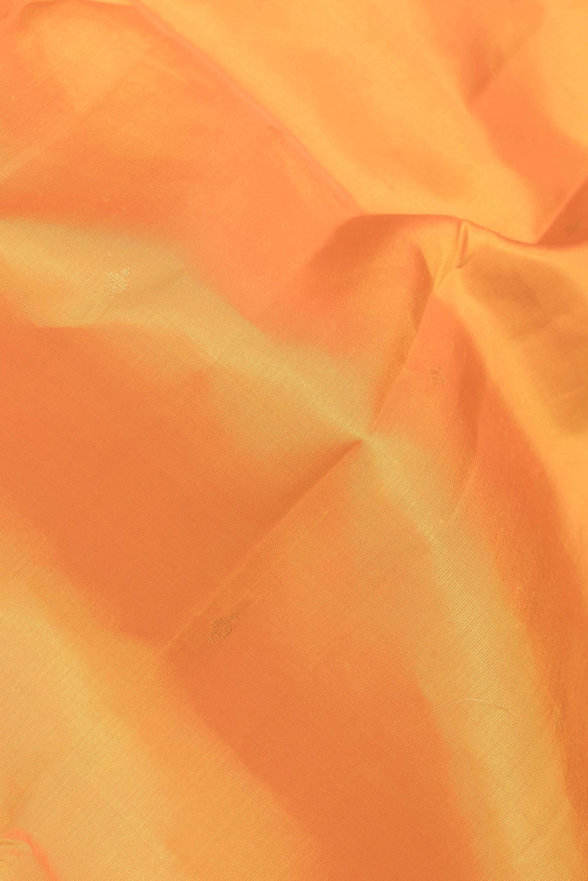 Close up of Orange Dual Tone Kanjivaram Silk Saree with Zari Butta on the body and Zari Border.  displaying folds