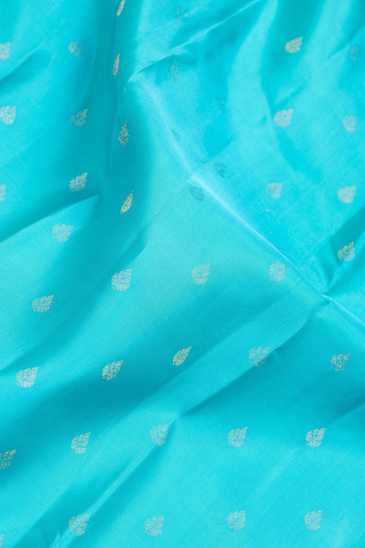Close up of Sky Blue Dual Tone Kanchipuram Silk Saree with Zari Butta on the body and Zari And Thread Border.  displaying folds
