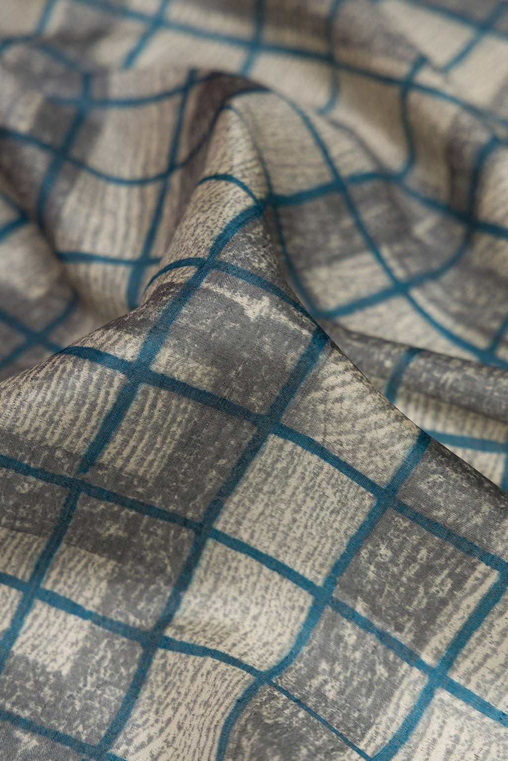 Close up of Grey Dual Tone Tussar Silk Saree with Checked design on the body and Fancy Border.  displaying folds