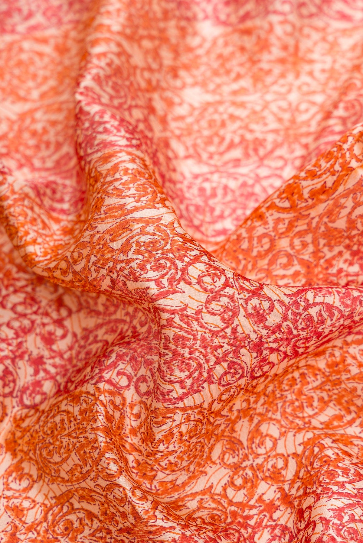 Close up of Orange Dual Tone Tussar Silk Saree with Printed design on the body and Printed Border.  displaying folds
