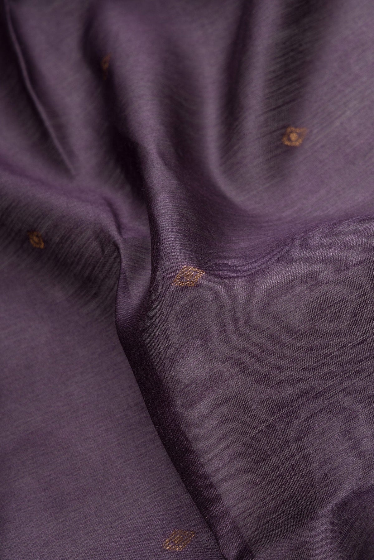 Close up of Violet Dual Tone Tussar Silk Saree with Zari Butta on the body and Ikat Border.  displaying folds