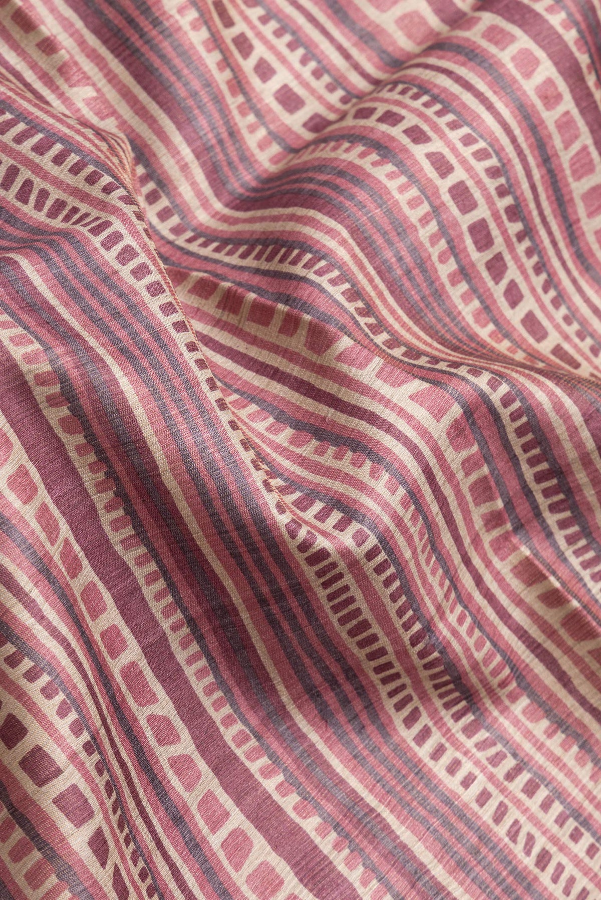 Close up of Beige Dual Tone Tussar Silk Saree with Printed design on the body and Printed Border.  displaying folds