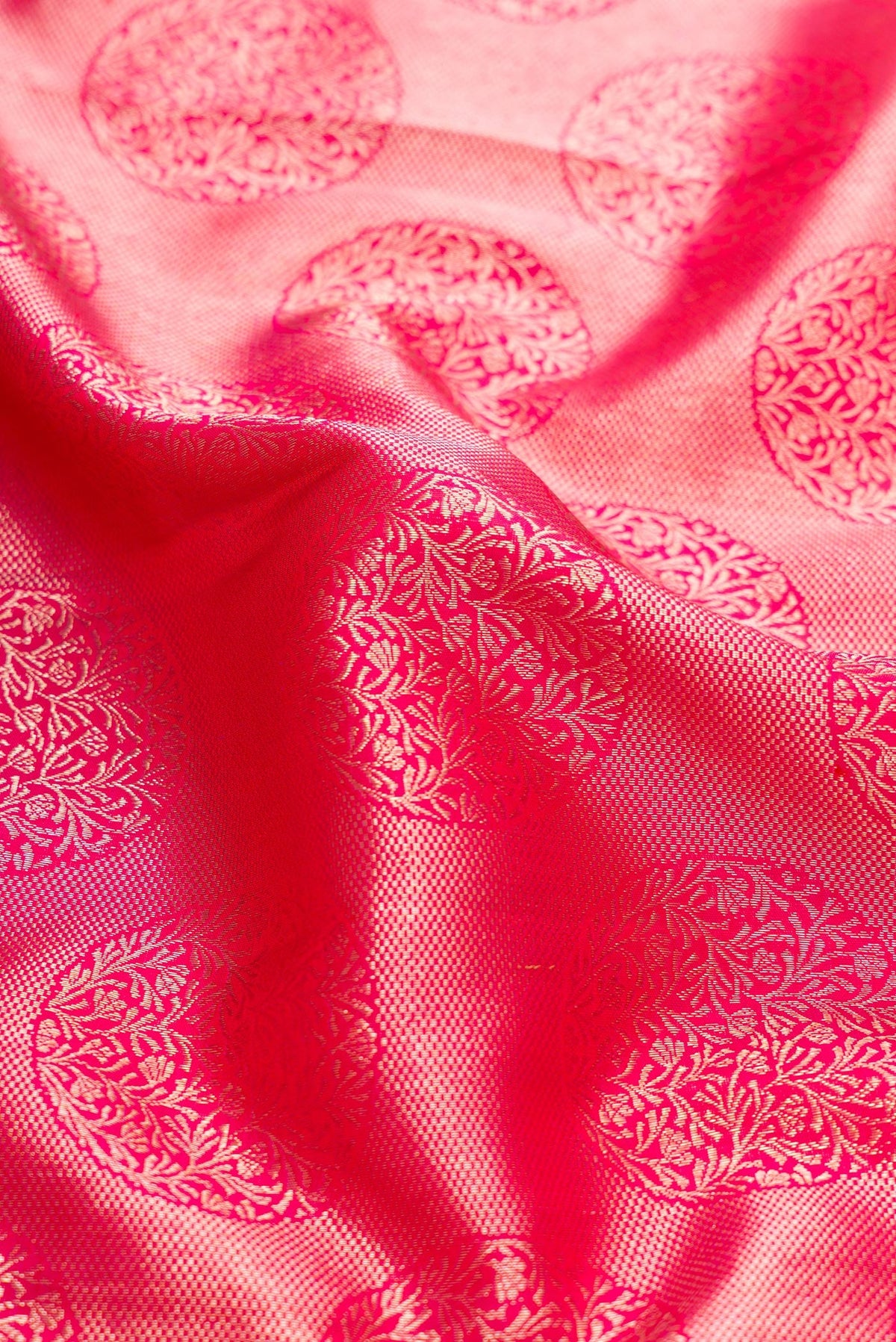 Close up of Pink Dual Tone Kanchipuram Silk Saree with Zari Butta on the body and Zari Border.  displaying folds