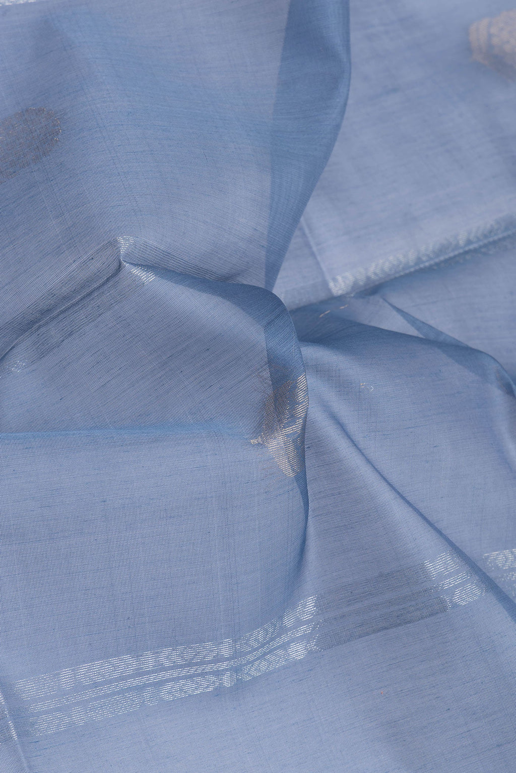 Close up of Blue Silk Cotton Saree with Zari Butta on the body and Zari Border.  displaying folds
