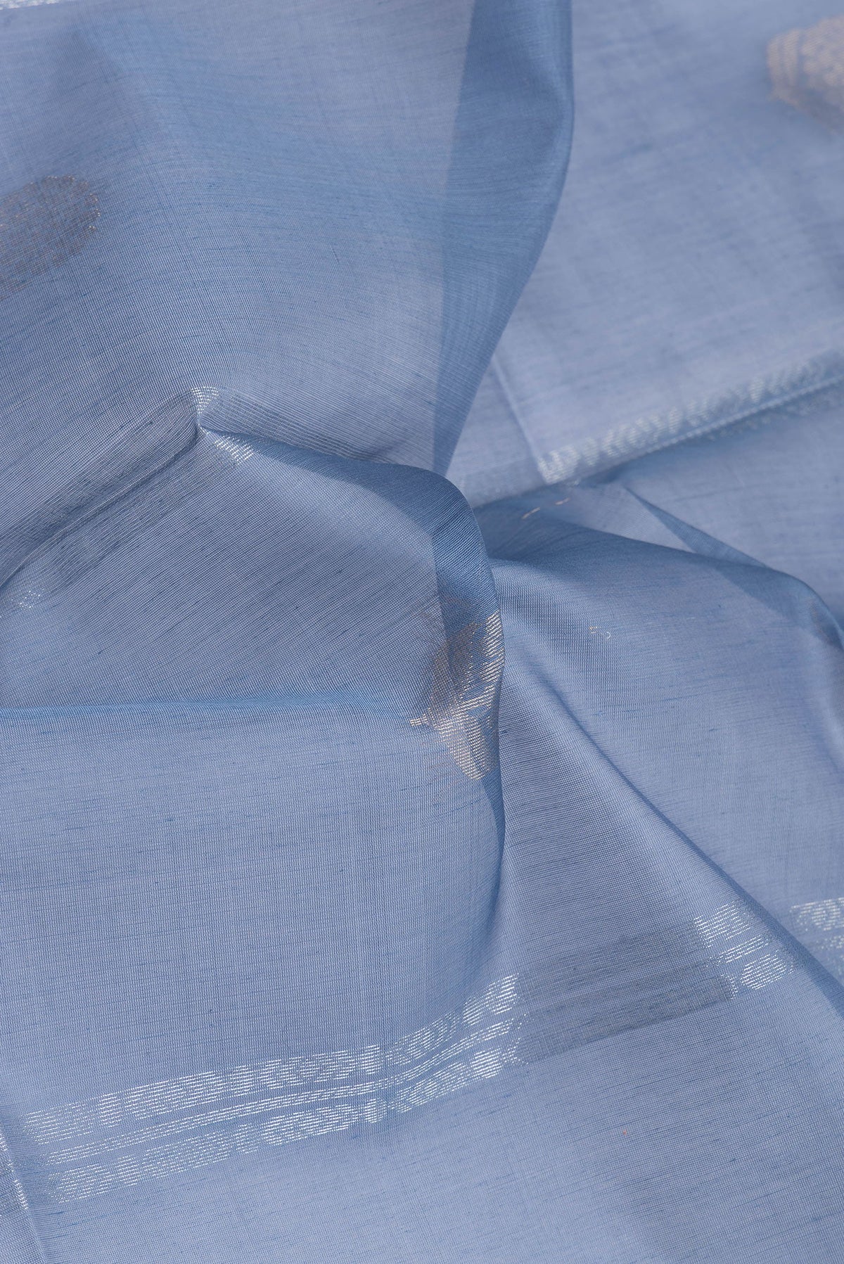 Close up of Blue Silk Cotton Saree with Zari Butta on the body and Zari Border.  displaying folds