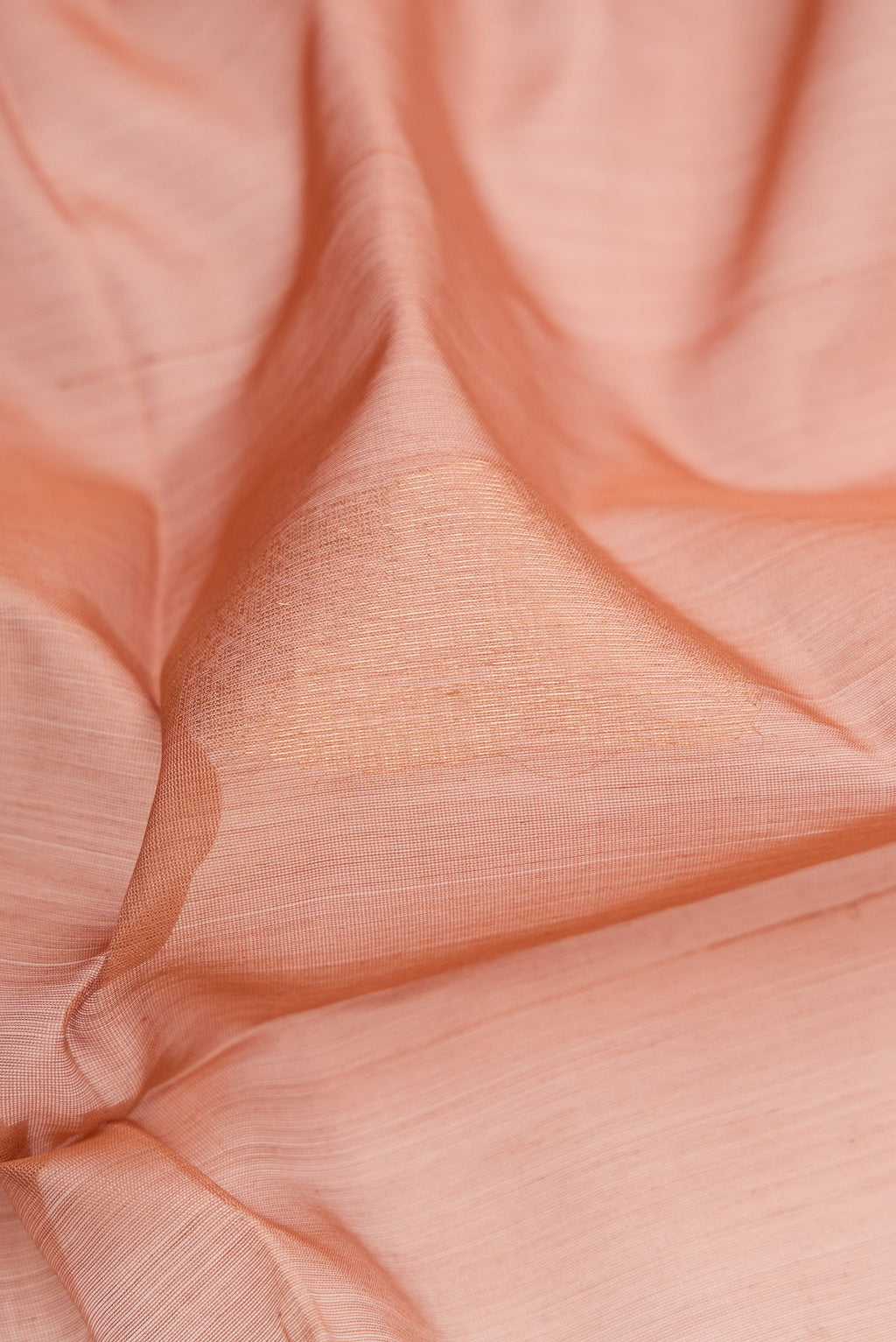 Close up of Rose Gold Silk Cotton Saree with Zari Butta on the body and Zari Border.  displaying folds