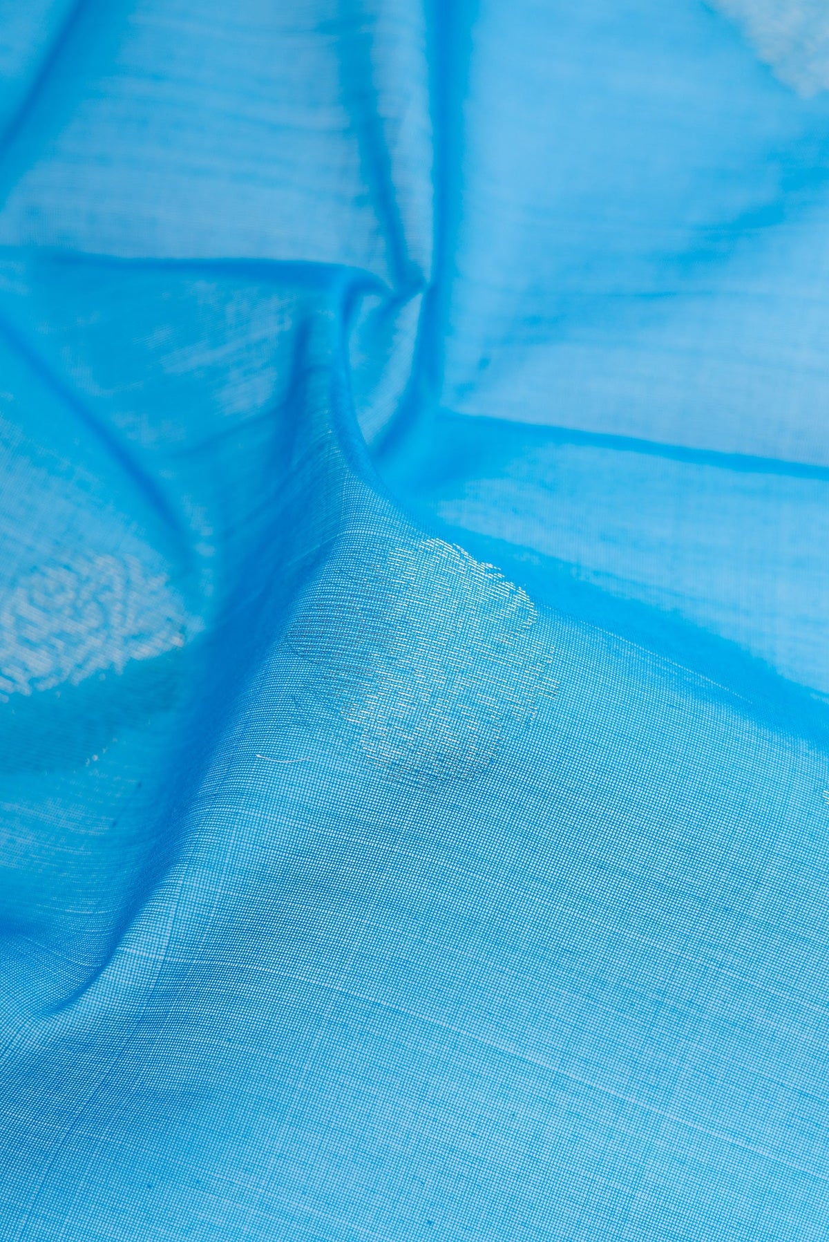 Close up of Sky Blue Silk Cotton Saree with Zari Butta on the body and Zari Border.  displaying folds