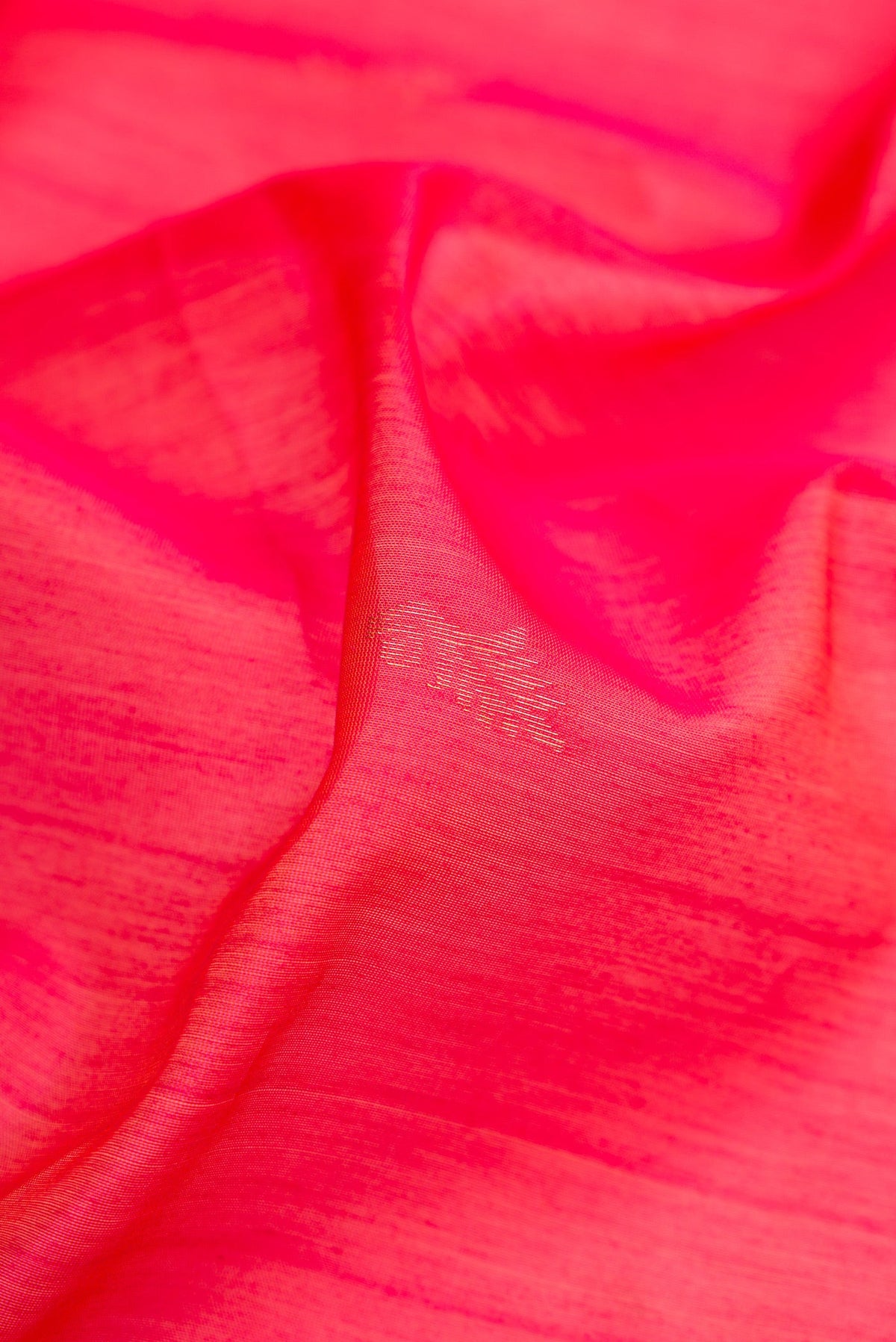 Close up of Pink Silk Cotton Saree with Zari Butta on the body and Zari Border.  displaying folds