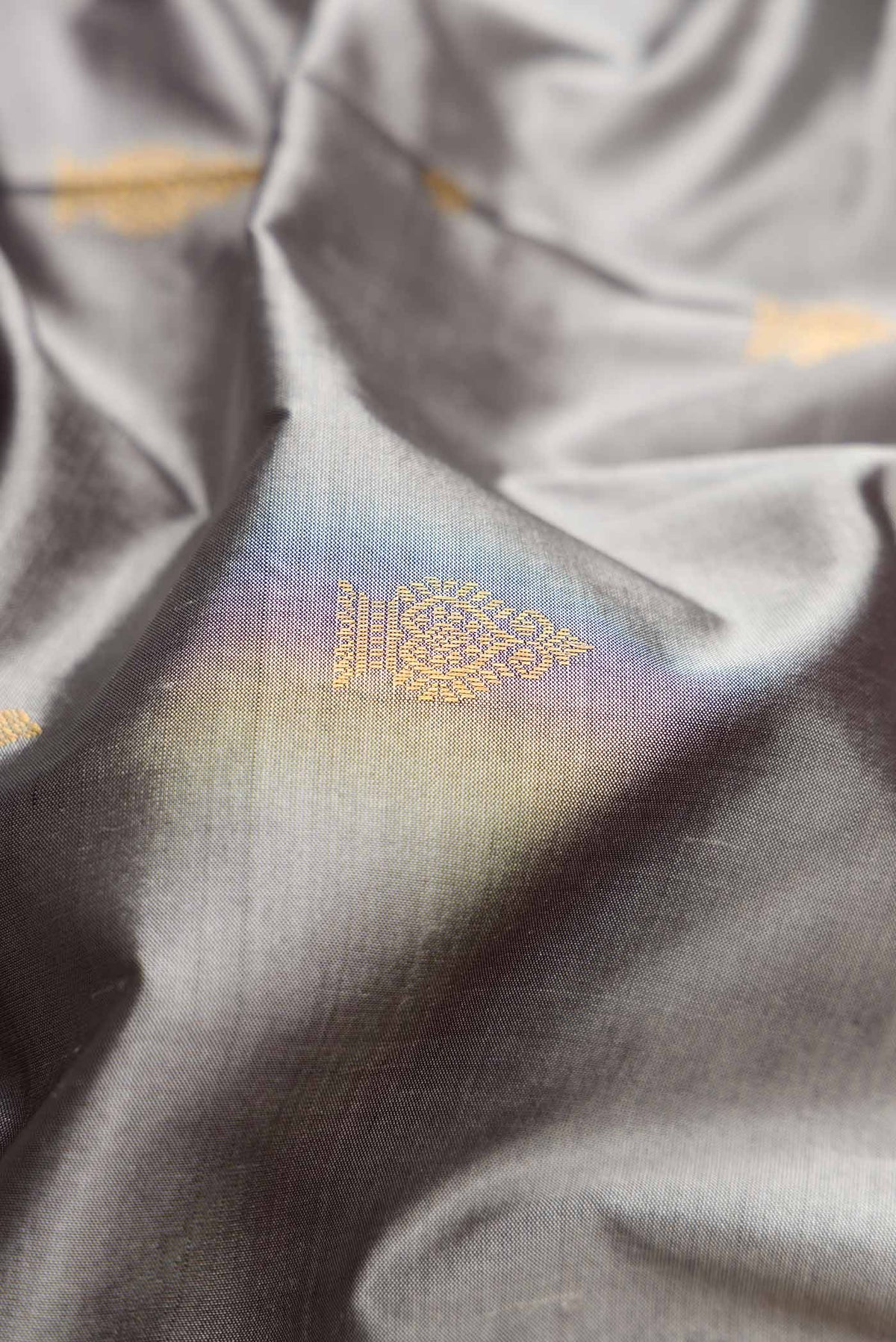 Close up of Grey Dual Tone Kanchipuram Silk Saree with Zari Butta on the body and Temple Border.  displaying folds