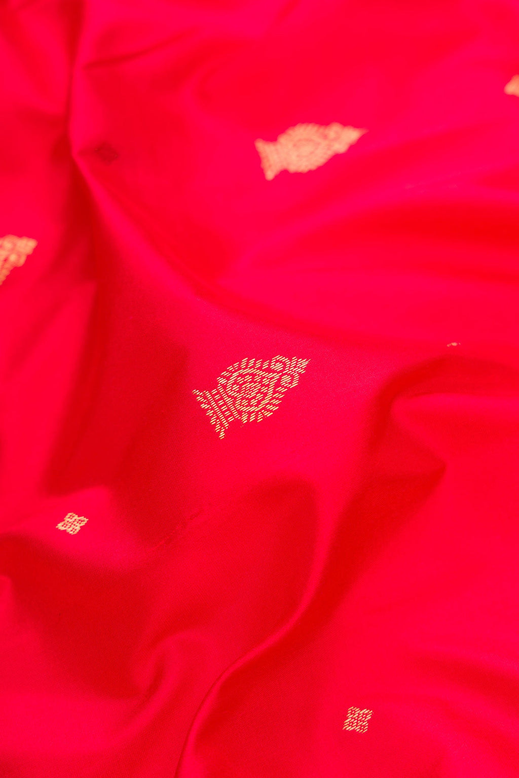 Close up of Red Dual Tone Kanchipuram Silk Saree with Zari Butta on the body and Temple Border.  displaying folds