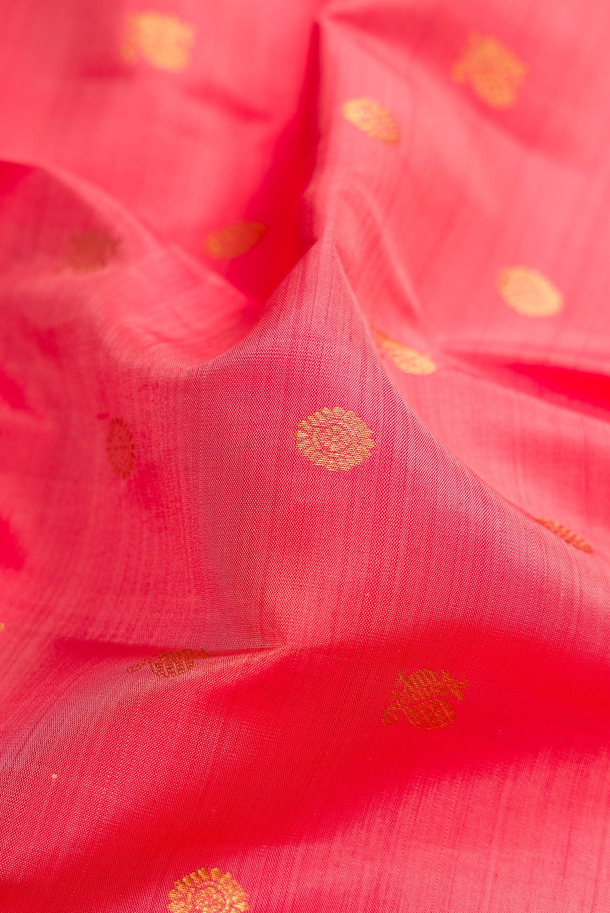 Close up of Pink Kanjivaram Silk Saree with Zari Butta on the body and Zari Border.  displaying folds