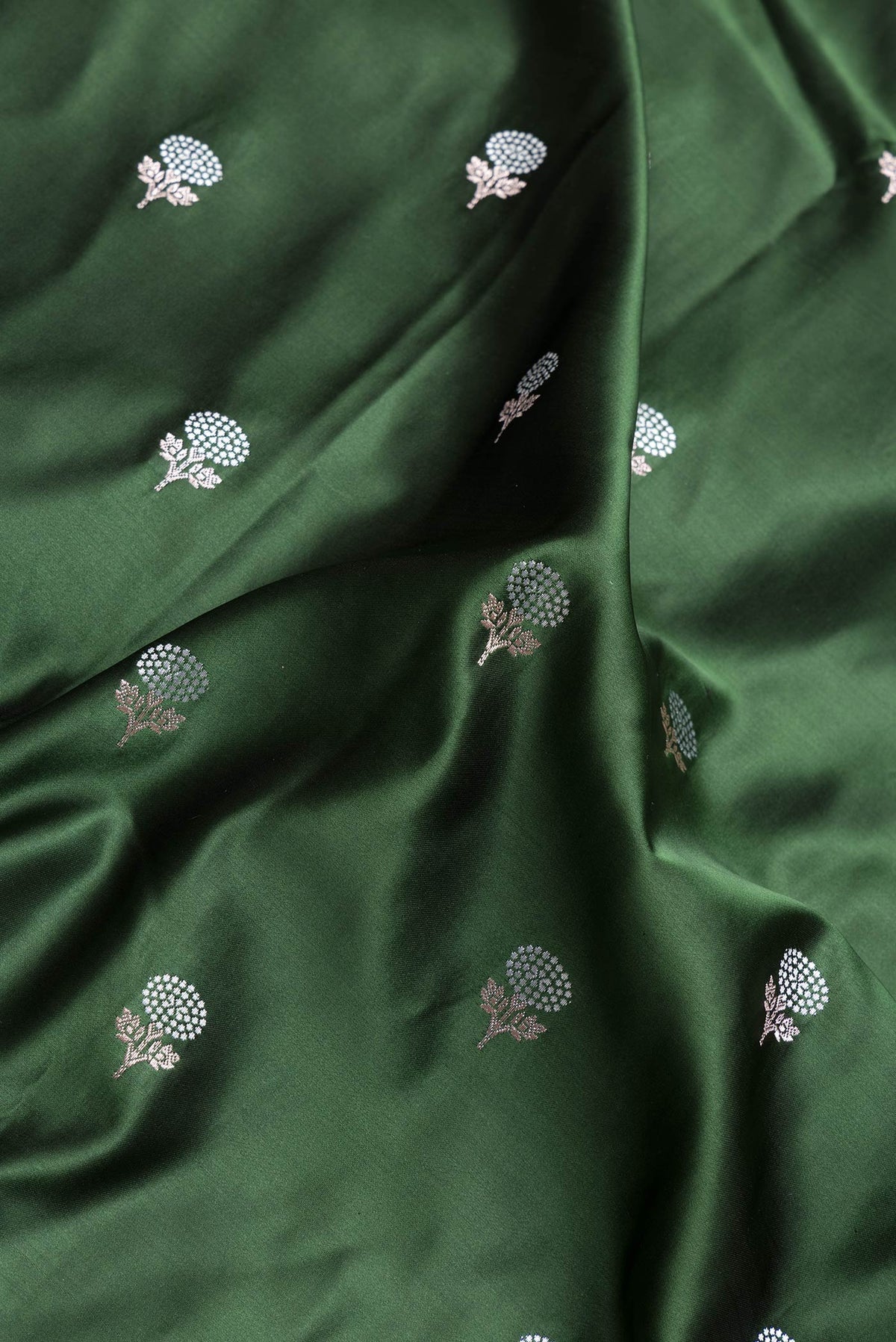 Close up of Bottle Green Dual Tone Banarasi Silk Saree with Zari Butta on the body and Zari Border.  displaying folds