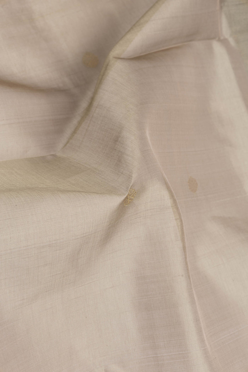 Close up of Dark Beige Silk Cotton Saree with Zari Butta on the body and Zari Border.  displaying folds