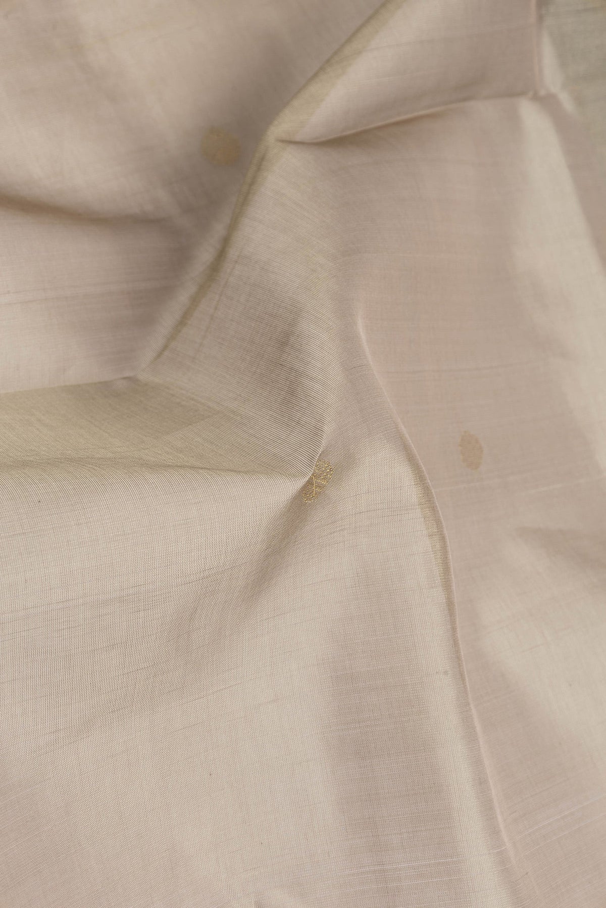 Close up of Dark Beige Silk Cotton Saree with Zari Butta on the body and Zari Border.  displaying folds