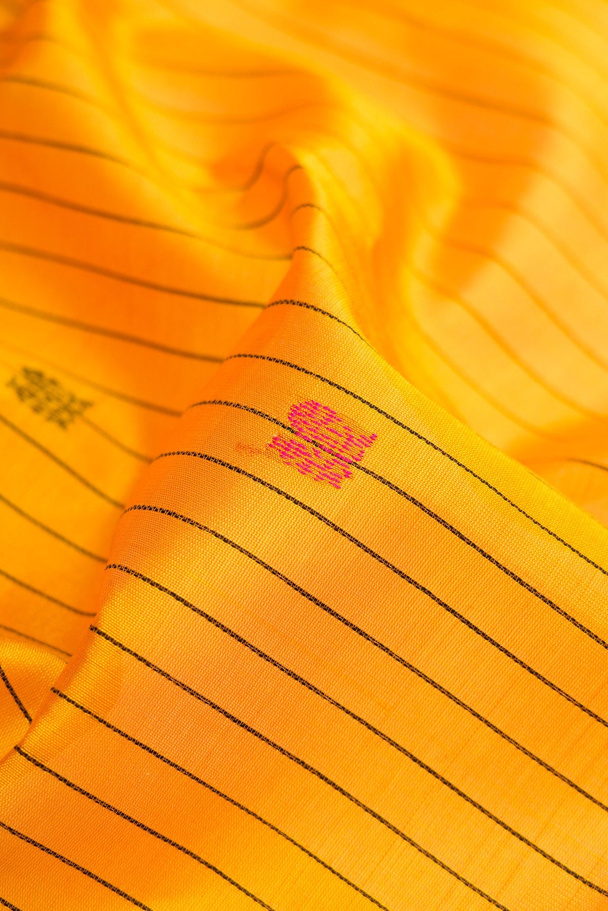 Close up of Yellow Silk Cotton Saree with Stripes on the body and Zari Border.  displaying folds