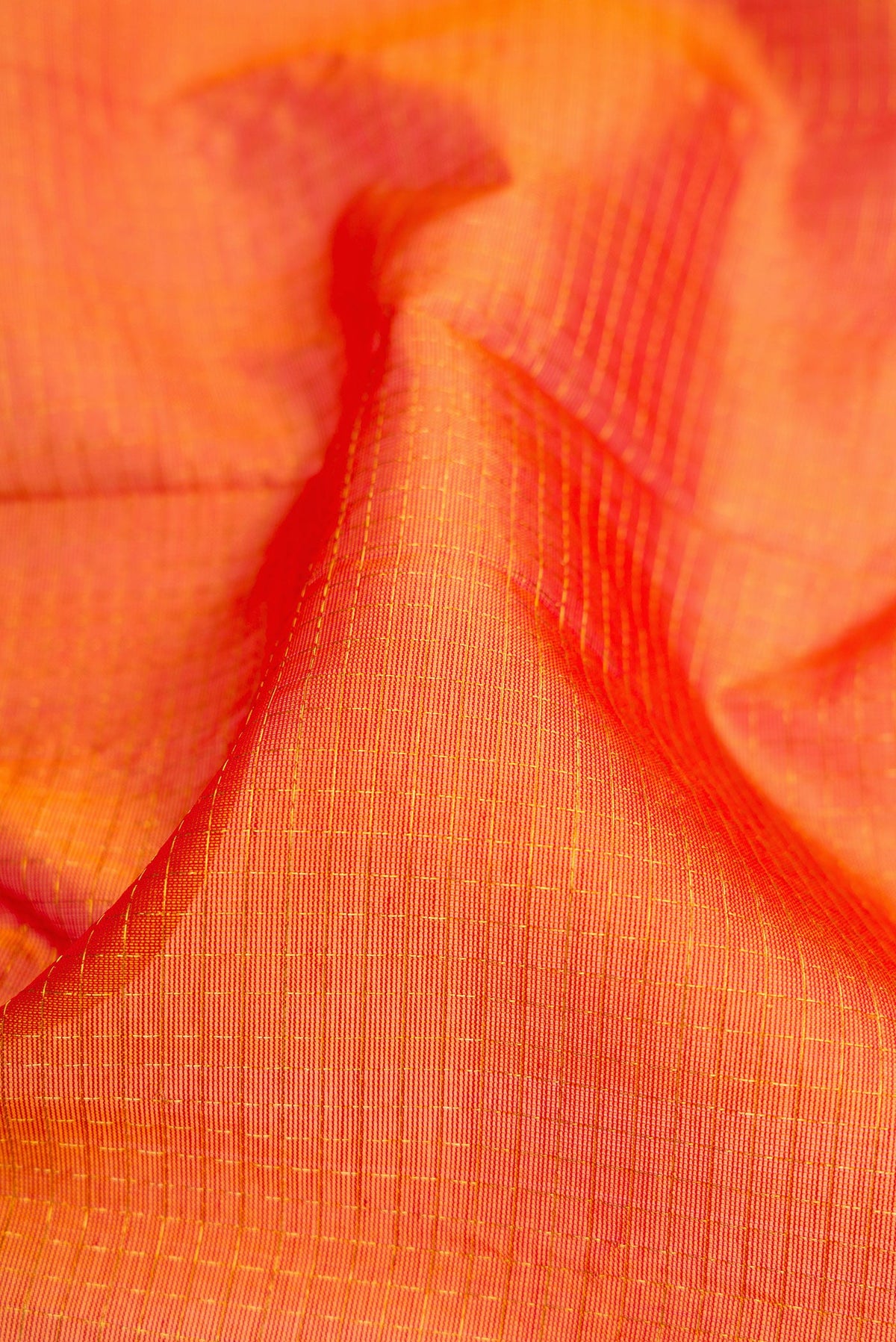 Close up of Orange Dual Tone Silk Cotton Saree with Checked design on the body and Zari Border.  displaying folds