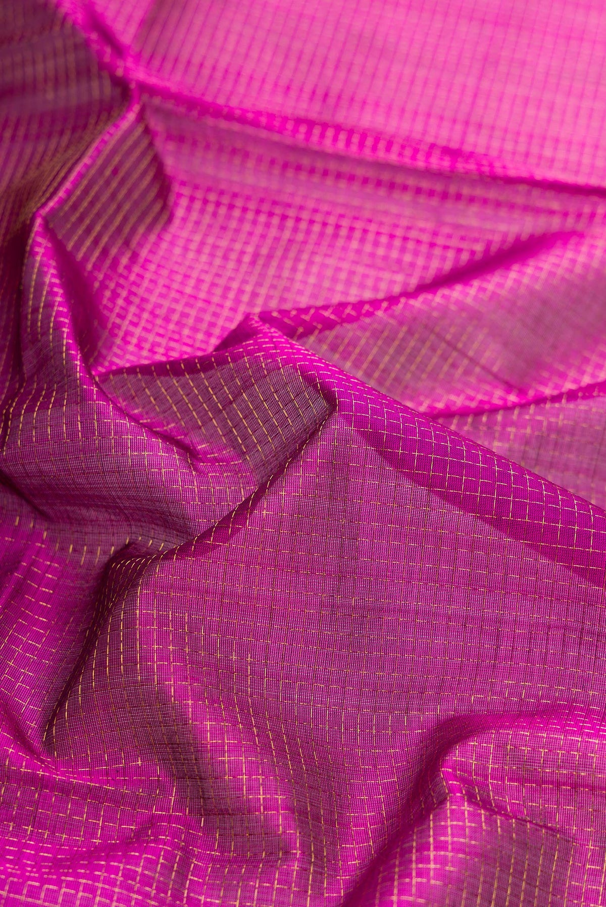 Close up of Magenta Dual Tone Silk Cotton Saree with Checked design on the body and Zari Border.  displaying folds