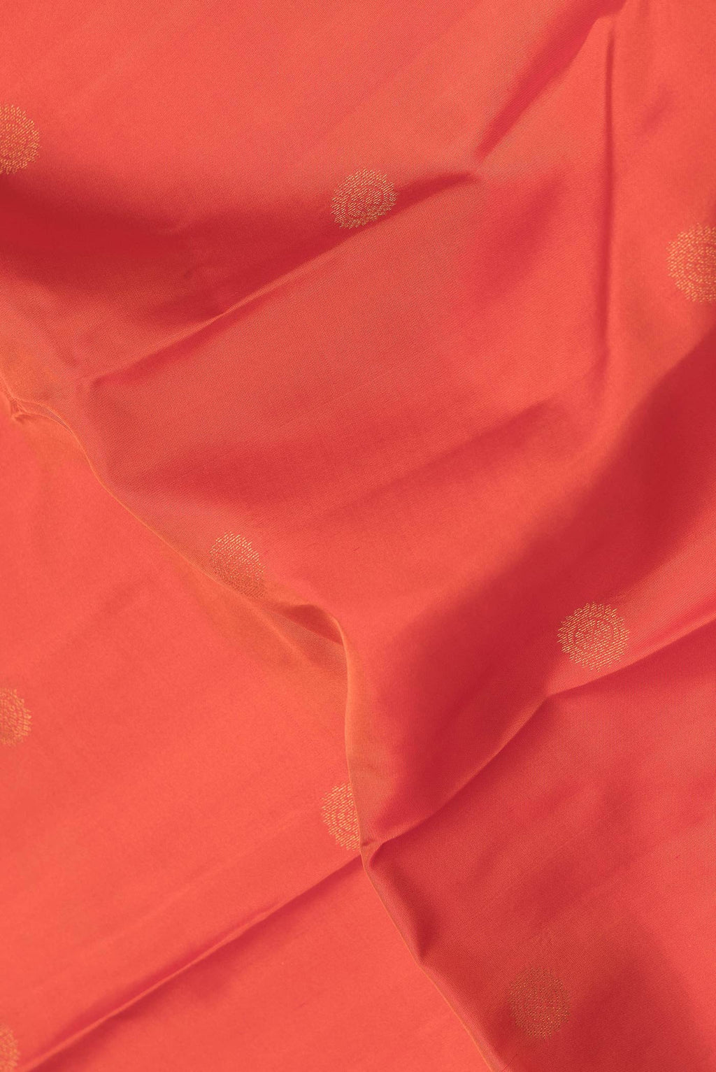 Close up of Orange Dual Tone Kanchipuram Silk Saree with Zari Butta on the body and Zari Border.  displaying folds