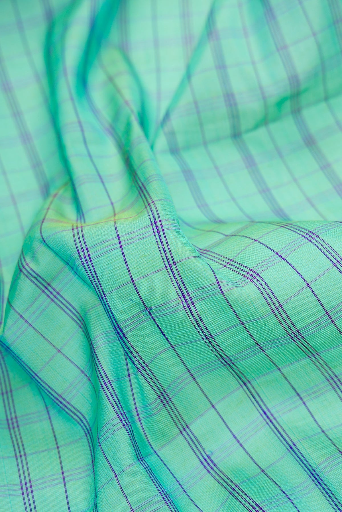 Close up of Sea Green Dual Tone Gadwal Silk Saree with Checked design on the body and Temple Border.  displaying folds