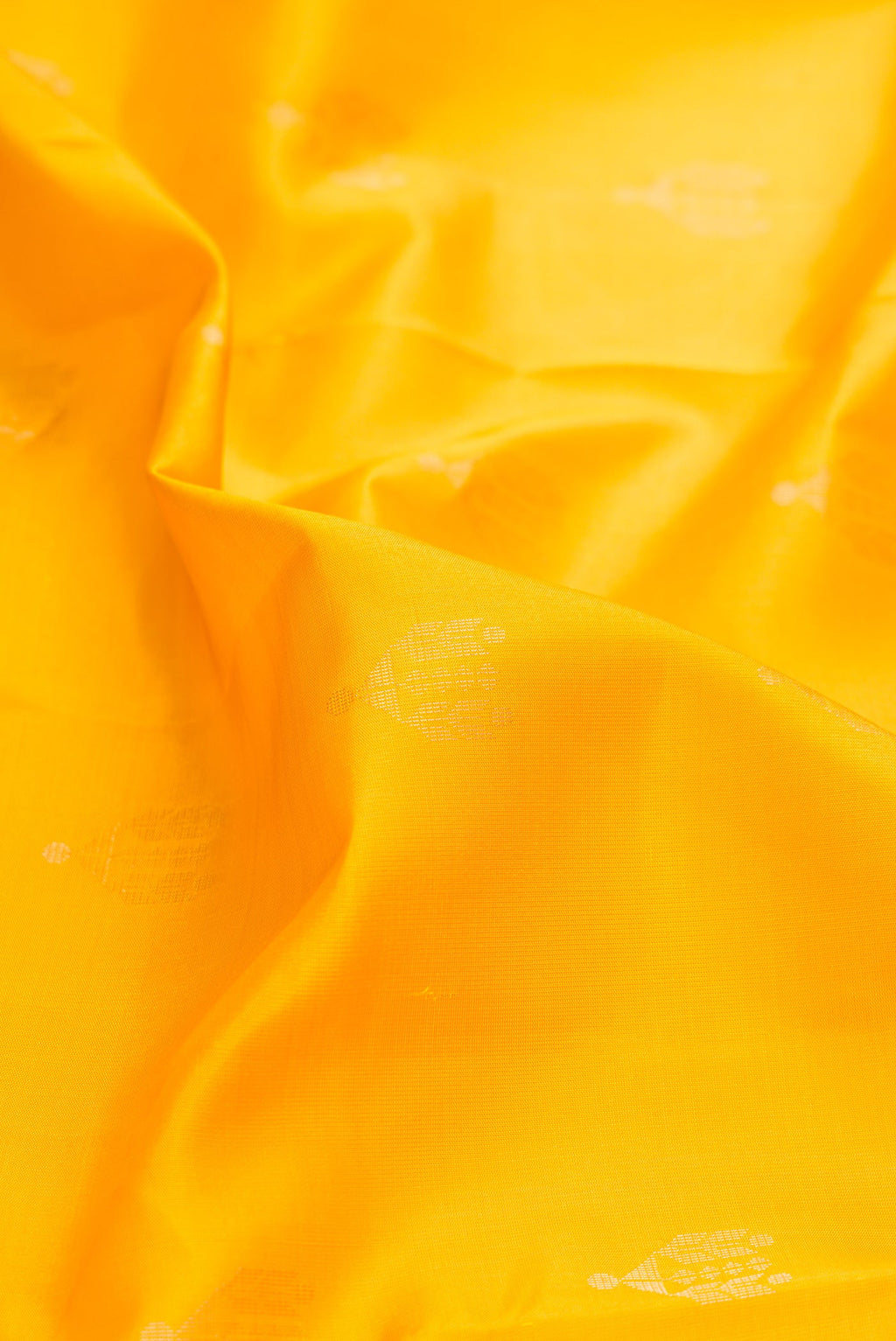 Close up of Yellow Dual Tone Soft Silk Saree with Zari Butta on the body and Zari Border.  displaying folds