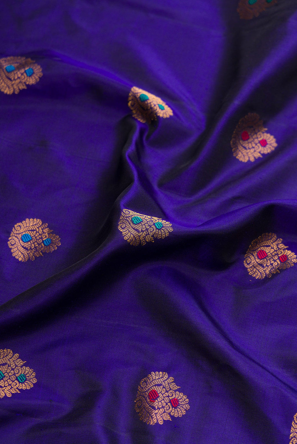 Close up of Royal Blue Dual Tone Gadwal Silk Saree with Zari And Thread Butta on the body and Zari Border.  displaying folds