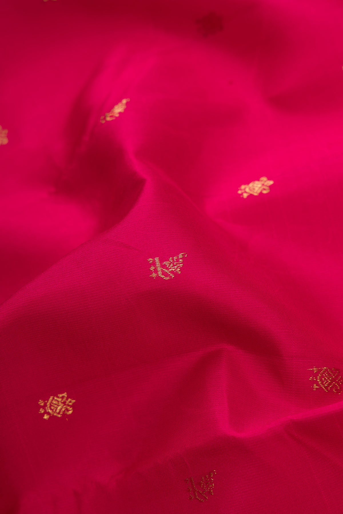 Close up of Maroon Dual Tone Kanchipuram Silk Saree with Zari Butta on the body and Temple Border.  displaying folds