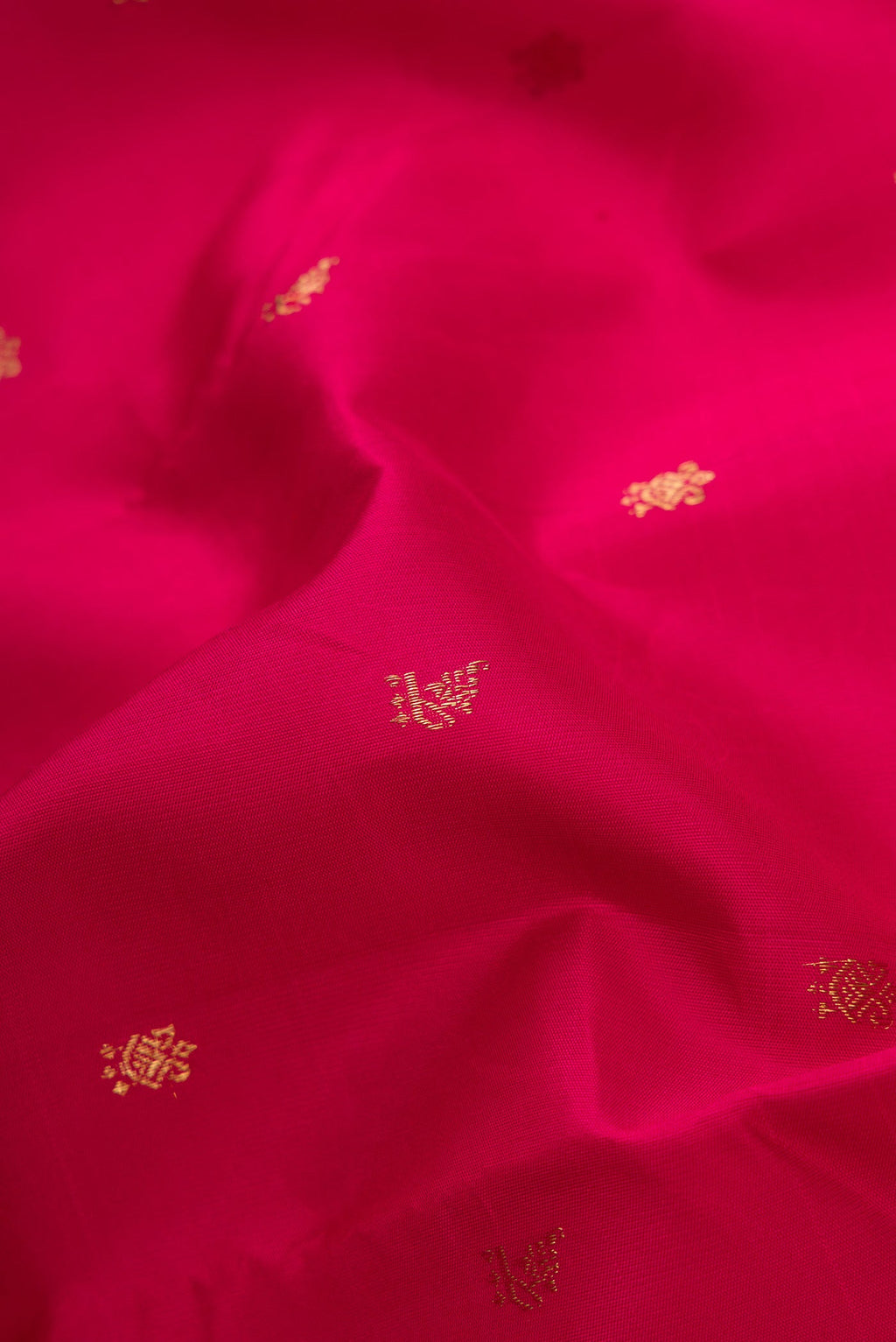 Close up of Maroon Dual Tone Kanchipuram Silk Saree with Zari Butta on the body and Temple Border.  displaying folds